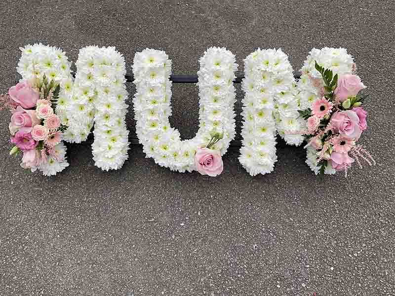 White and pink lettering for a funeral that spells out mum