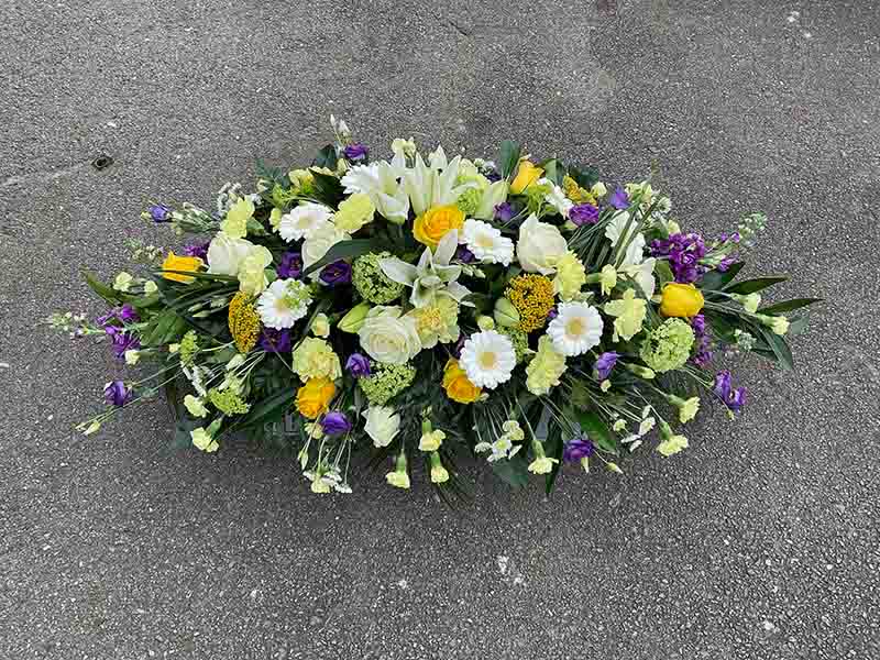 Purple yellow and white funeral flower spray