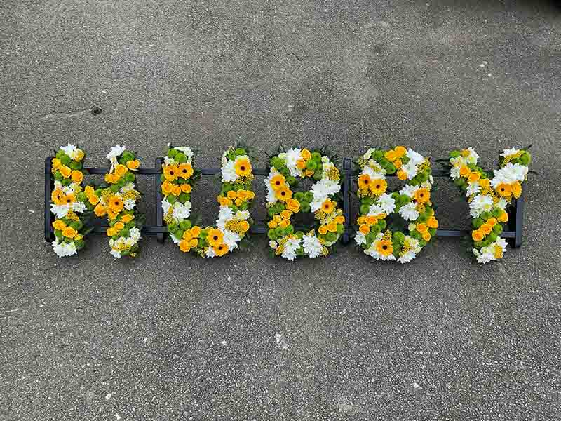 White green and yellow funeral flower writing spelling out Hubby