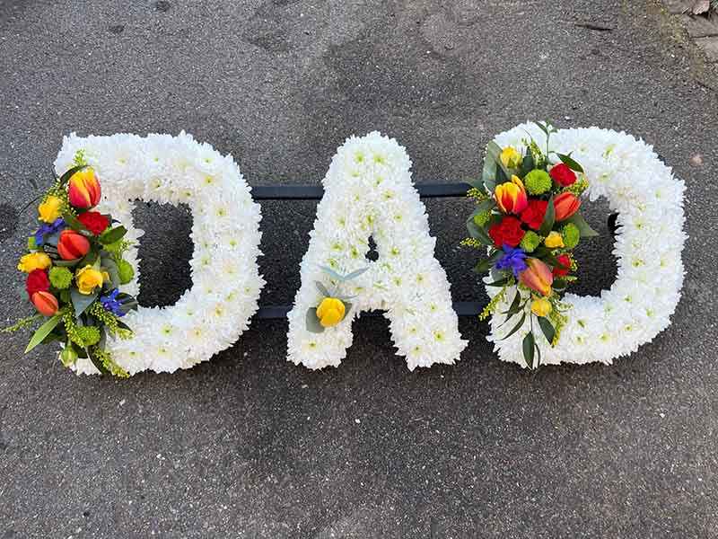 White funeral flower writing spelling out dad